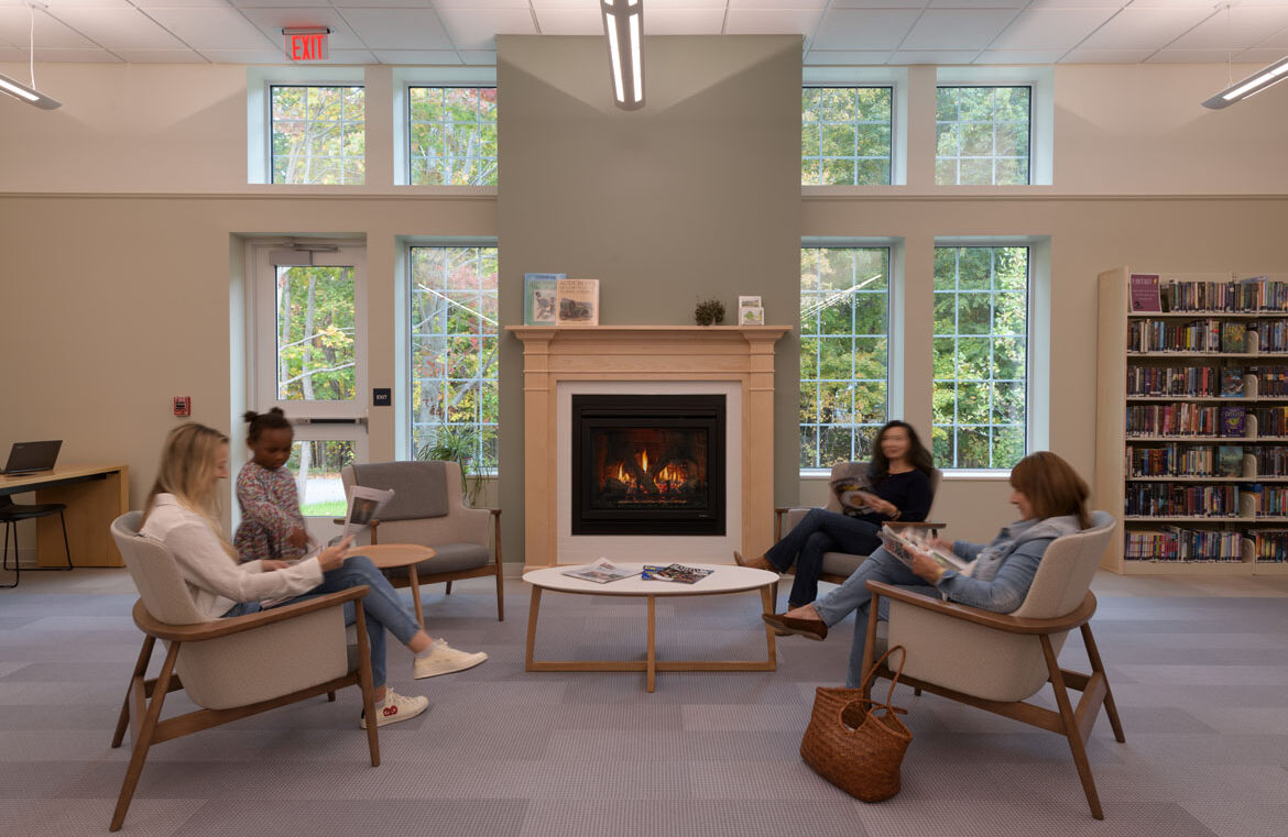 Fireplace seating with people reading inside North Hampton Public Library
